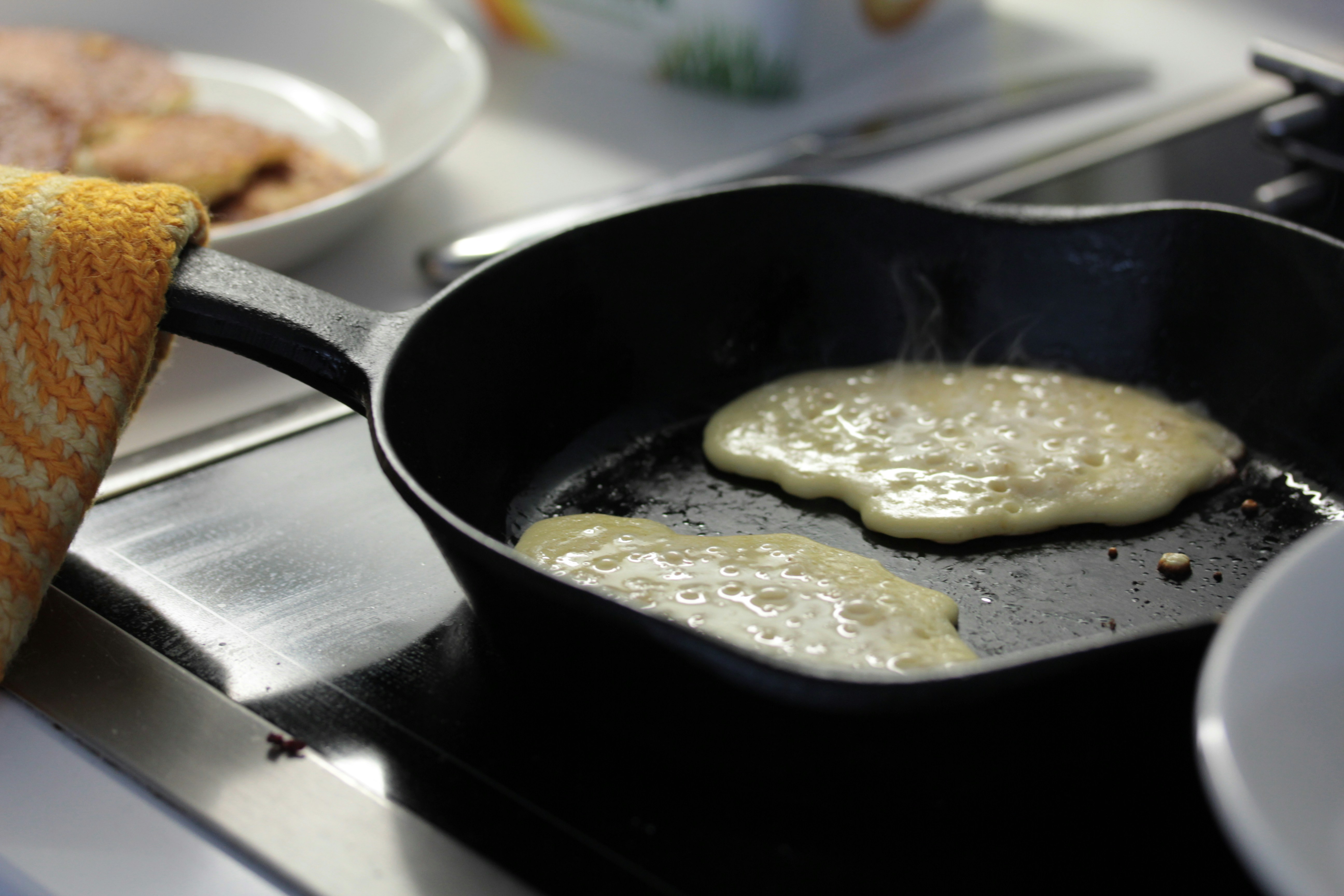 picture of an unready pancake on a pan.